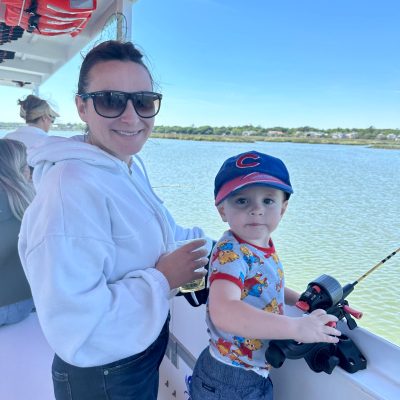 a person holding a baby next to a boat