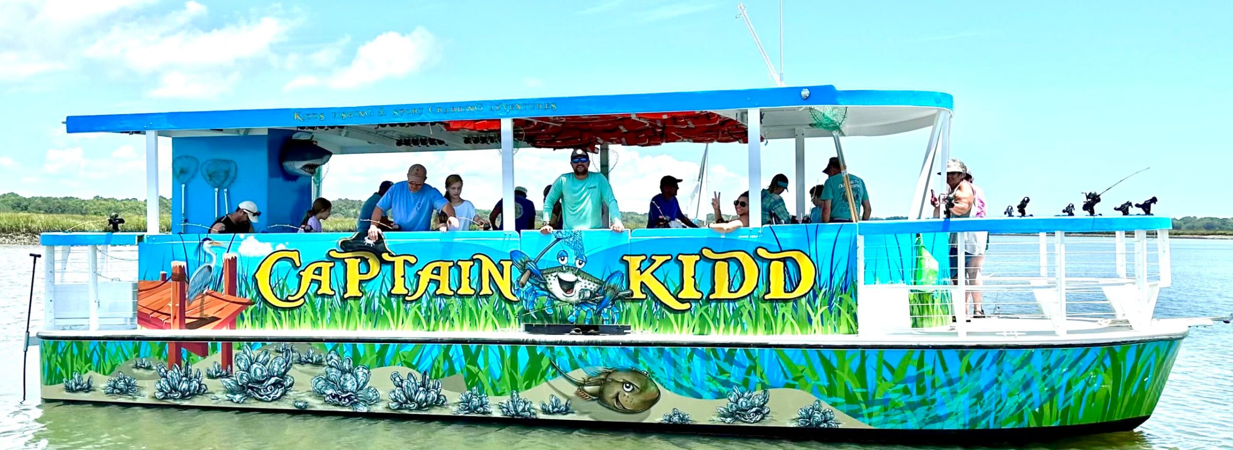 KiddProfileBoat2 a group of people riding on the back of a boat